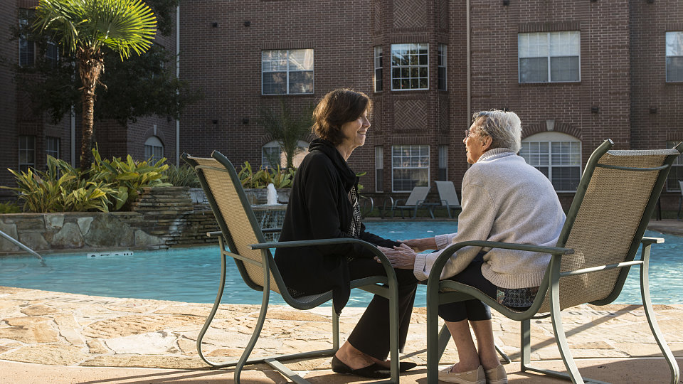 older woman sitting by pool with adult daughter