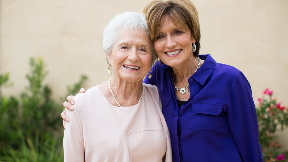 older lady with adult daughter smiling