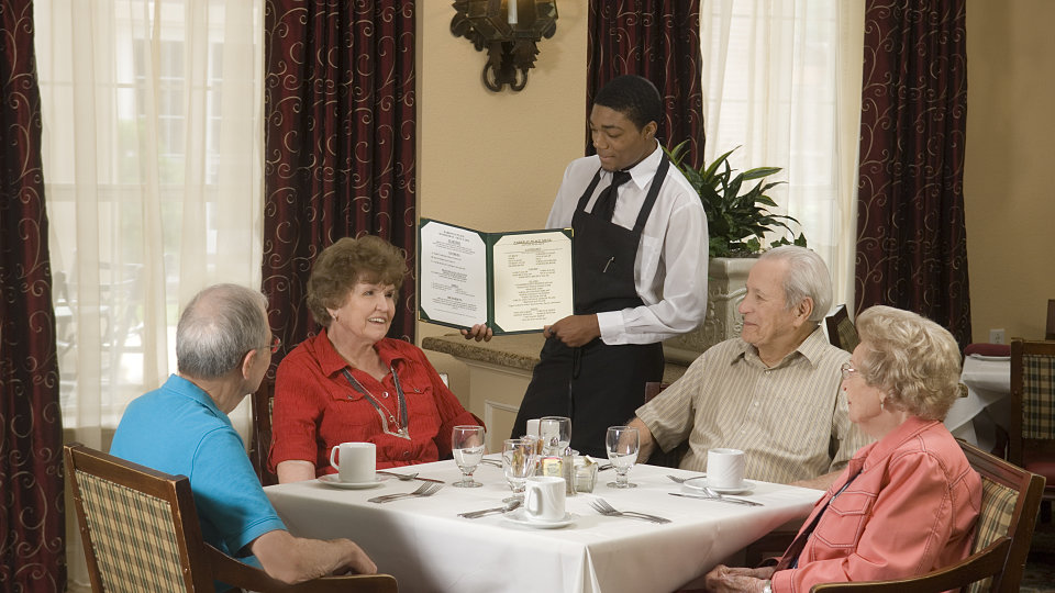 waiter showing senior residents the menu