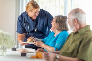 Nurse checking on residents eating in an assisted living facility