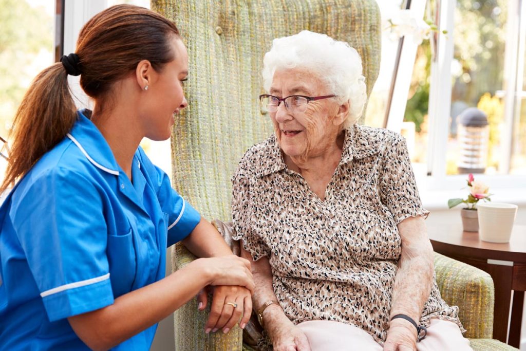 Senior talking to nurse in memory care