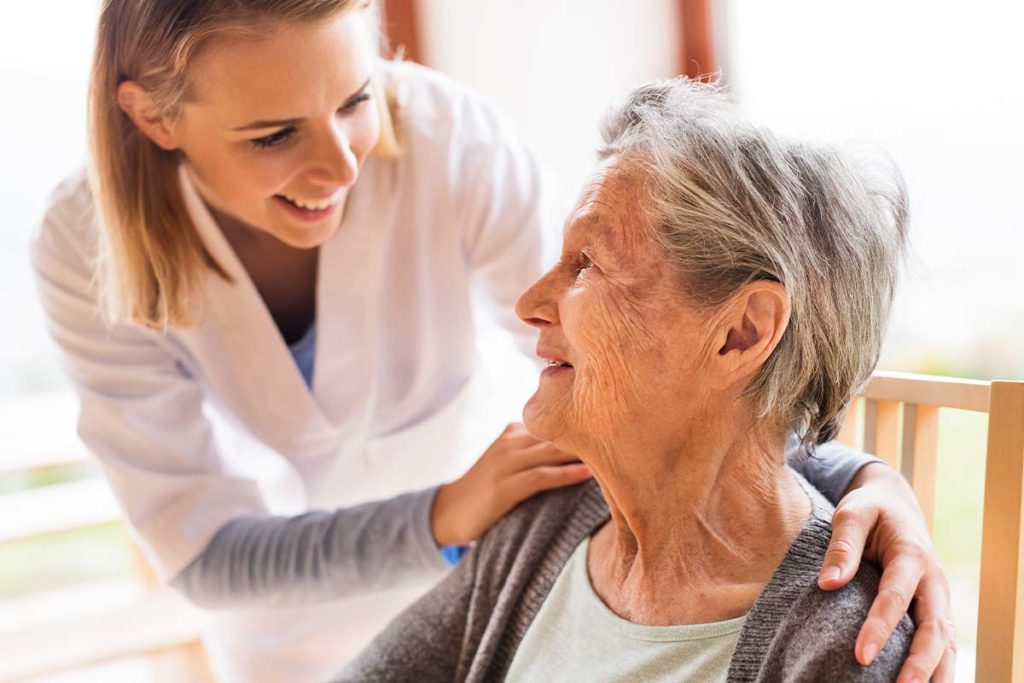 Patient in skilled nursing care looks up at nurse with admiration