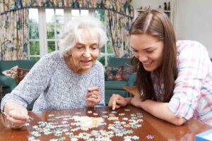 Caretaker helps senior with dementia patient mental stimulation