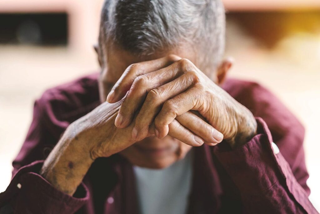 Senior rests head in hands, after discovering signs dementia is getting worse
