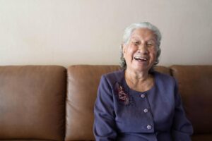 Senior smiles on couch after learning what senior speech therapy is