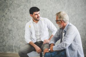 Senior talks to speech therapist as he learns speech therapy exercises for seniors