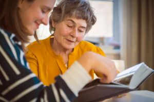 Senior reads book with health professional after learning the cost of memory care