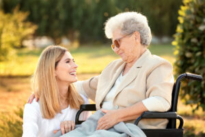 A woman sitting in a wheelchair is receiving care from a Baptist Retirement Community team member during respite care.