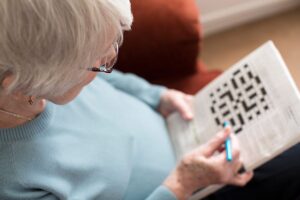 Woman plays crosswords after discovering what to know about memory care