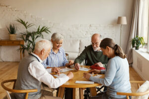 Group of friends gathers at table as they discuss if there is an age requirement for senior living