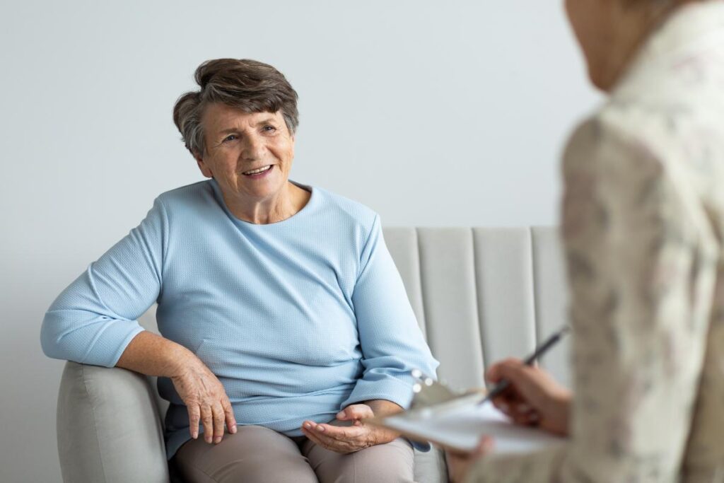 A smiling senior adult woman talks to one of our team members about financial planning for senior long-term care.