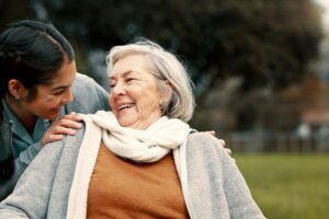 A senior woman smiles at a team member helping her to stay active.