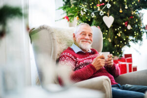 Man sits in chair after discovering holiday decorating tips for senior living apartments