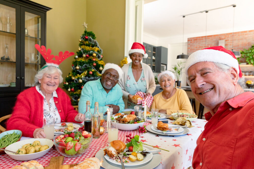 Family sits at holiday table and dicusses the benefits of choosing senior living for loved one